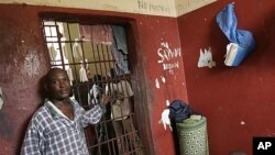 In this June 2, 2007 photo, prisoners stand inside one of the small, crowded cells as others look on from the corridor, at the central prison in Monrovia, Liberia, September 21, 2011.