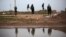 FILE - Kurdish female members of the Popular Protection Units stand guard at a check point near the northeastern city of Qamishli, Syria, March 3, 2013.