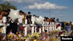 총기 난사 사건이 발생한 미국 텍사스 주 엘파소에서 시민들이 지난 6일 희생자들을 추모하기 위해 기념비에 모여 있다. 