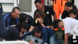 Para anggota keluarga menangisi jenazah nelayan Taiwan, Hung Shih-cheng yang tewas ditembak penjaga pantai Filipina (22/5). 