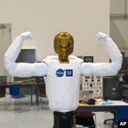 Robonaut (R2), the dexterous humanoid astronaut helper, flexes its mechanical muscles prior to its transport aboard space shuttle Discovery to the International Space Station.