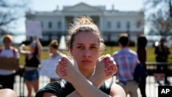 Gwendolyn Frantz, 17, of Kensington, Md., stands in front of the White House during a student protest for gun control, Feb. 21, 2018, in Washington. (AP Photo/Evan Vucci)