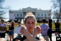 Gwendolyn Frantz, 17, of Kensington, Md., stands in front of the White House during a student protest for gun control, Feb. 21, 2018, in Washington.