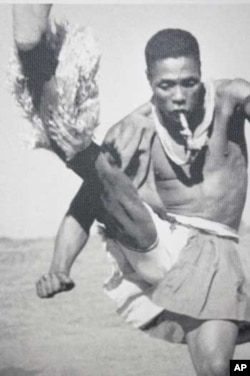 A Zulu man dances while blowing a whistle on a mine near Johannesburg in this photograph taken by Hugh Tracey in the late 1940s