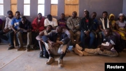 Migrants sit in the police commissioner's office after being arrested for attempting to bribe a police officer so they could pass a checkpoint without identification in Agadez, Niger, March 16, 2014. 