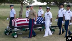FILE - In this July 27, 2015 file photo, military pallbearers escort the exhumed remains of unidentified crew members of the USS Oklahoma killed in the 1941 bombing of Pearl Harbor that were disinterred from a gravesite at the National Memorial Cemetery of the Pacific in Honolulu.