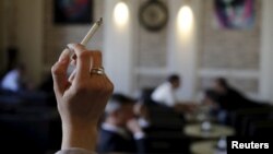FILE: A woman holds a cigarette in a cafe in Vienna, Austria.