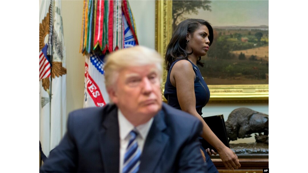 FILE - In this March 12, 2017 file photo, White House Director of communications for the Office of Public Liaison Omarosa Manigault, right, walks past President Donald Trump during a meeting on healthcare in the White House.
