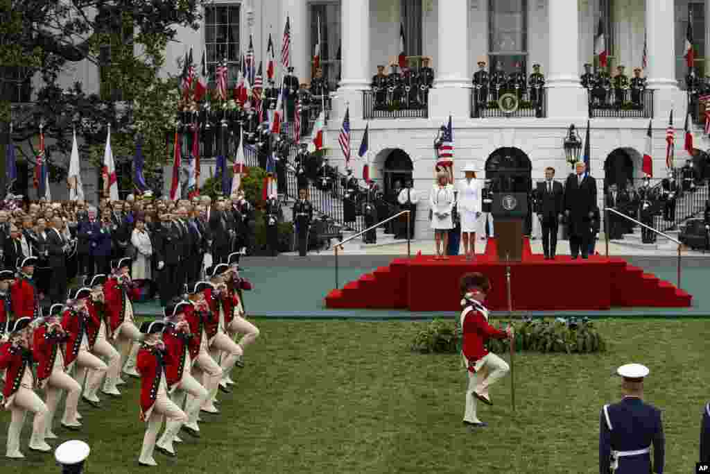 Brigitte Macron, first lady Melania Trump, French President Emmanuel Macron, and President Donald Trump look on during a State Arrival Ceremony on the South Lawn of the White House in Washington.