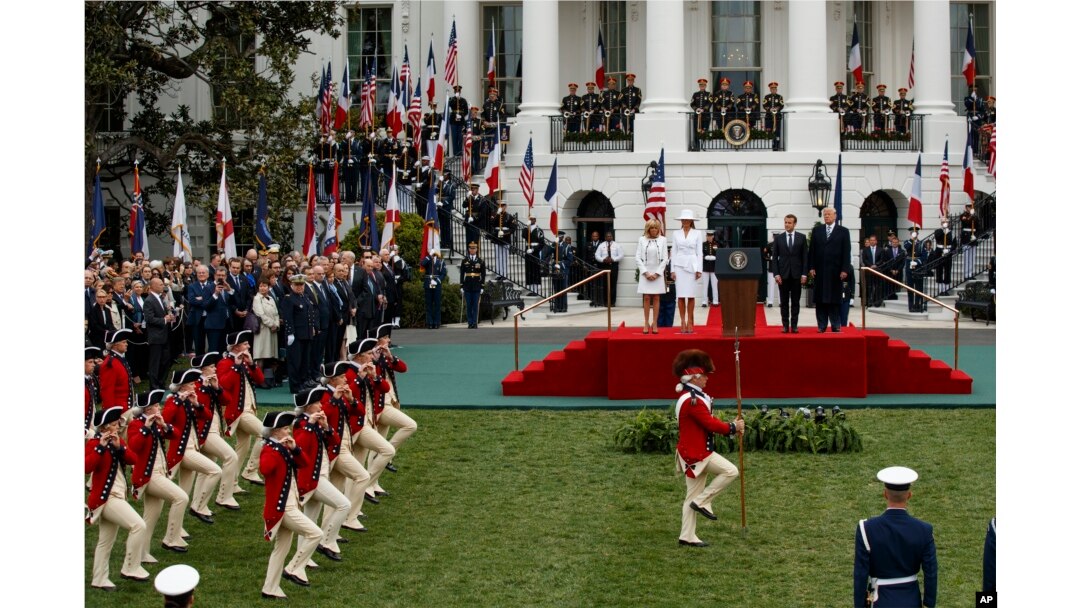 Brigitte Macron, first lady Melania Trump, French President Emmanuel Macron, and President Donald Trump look on during a State Arrival Ceremony on the South Lawn of the White House, April 24, 2018, in Washington.