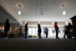 Evanston residents line up to vote at a polling station at Trinity Lutheran Church, in Evanston, Illinois, March 17, 2020.