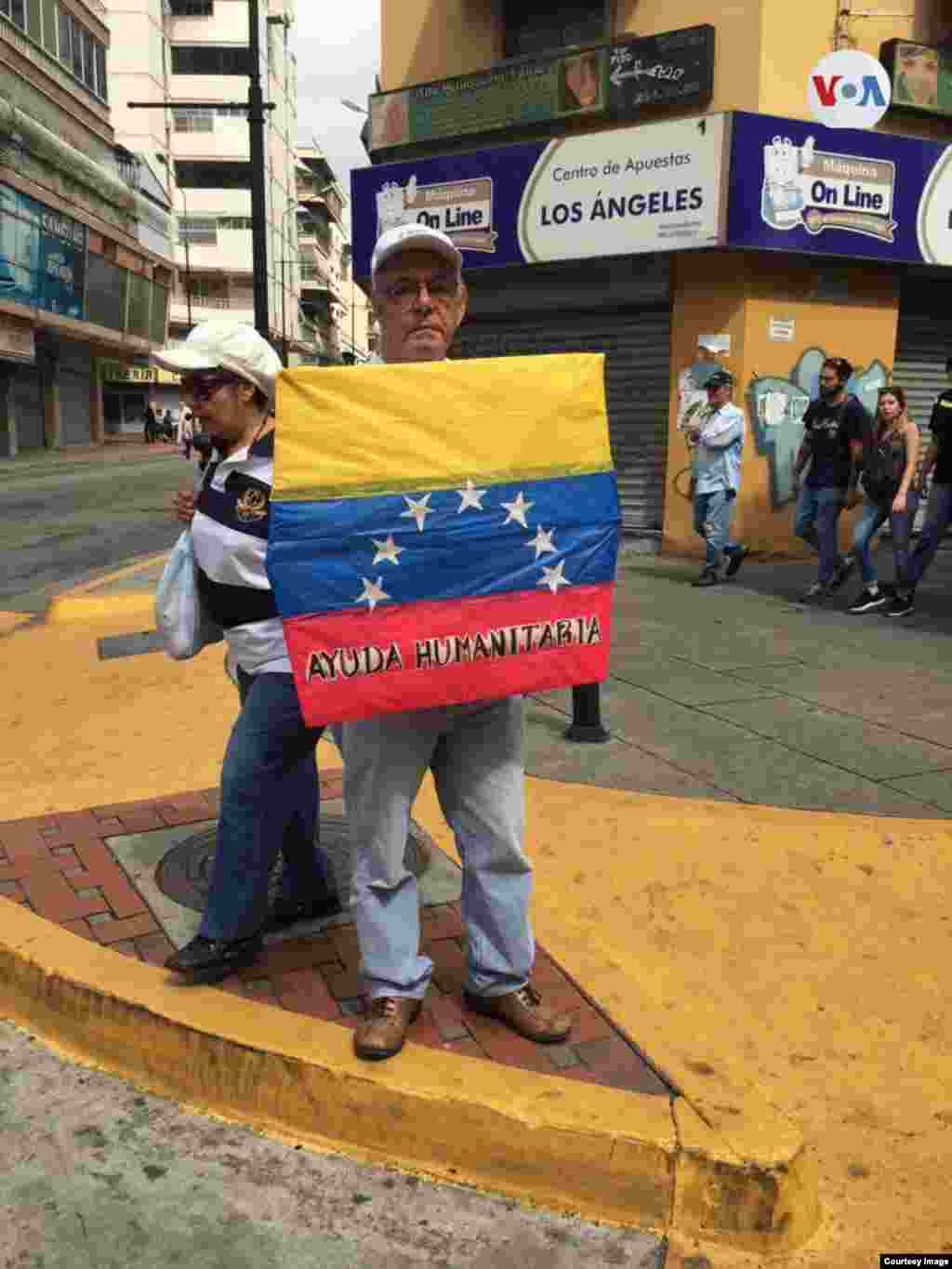 Un hombre venezolano carga la bandera de Venezuela durante protesta en Caracas.&nbsp;