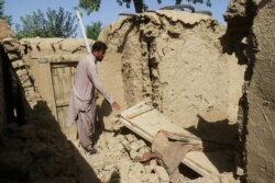 Seorang warga membersihkan bagian rumahnya yang rusak akibat gempa di Harnai, Balochistan, Pakistan, 7 Oktober 2021. (Foto: REUTERS/Naseer Ahmed)