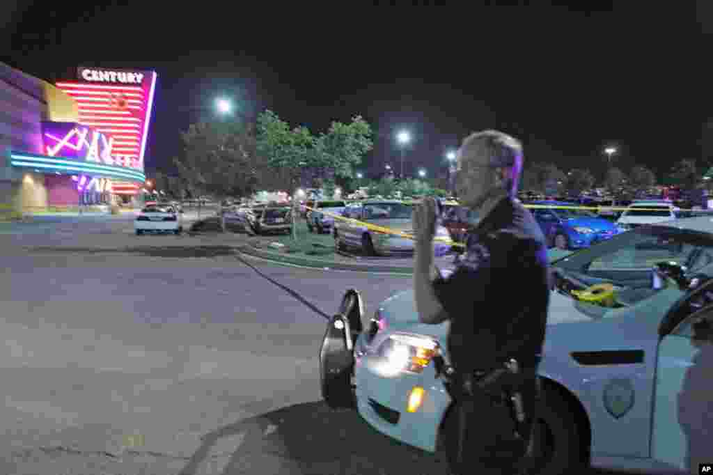 Seorang polisi Aurora berbicara lewat walkie-talkie di luar bioskop 16 Century di Mall Aurora di mana setidaknya 12 orang tewas dan sekitar 50-an orang terluka dalam penembakan di bioskop Century 16 di Aurora, Colorado (20/7).