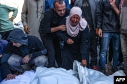 Palestinians react in front of the bodies people killed in an Israeli strike at the al-Aqsa Martyrs Hospital in Deir Al-Balah in the central Gaza Strip, Nov. 17, 2024.