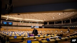 Dua anggota parlemen Eropa berada dalam ruang sidang yang kosong di Brussels, 10 Maret 2020. (Foto: dok). 
