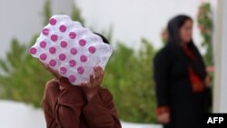 This picture taken during a media visit organized by Qatari authorities on Aug. 21, 2021, shows an Afghan man carrying bottled water inside a villa complex in Doha, where refugees who recently arrived from Afghanistan began to settle.