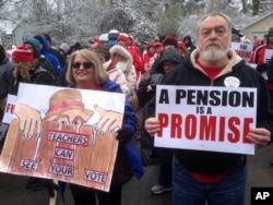 Debbie Burke, left, an elementary school teacher in Pike County, and her husband Gary Burke rally against a proposed pension overhaul bill, in Frankfort, Ky., March 21, 2018.