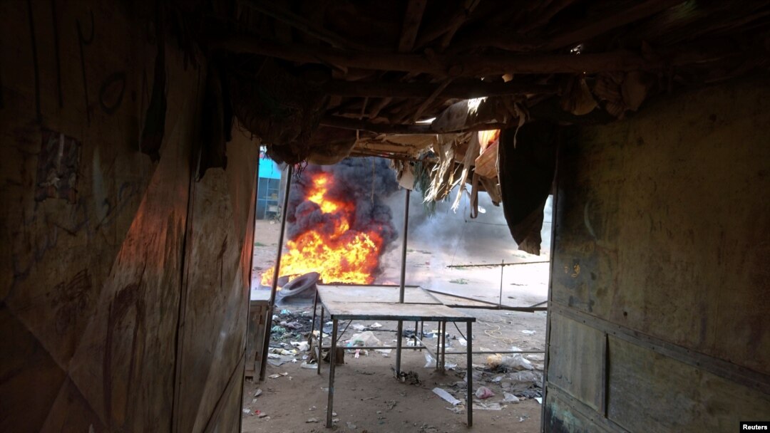 A fire is seen burning in a street during protests against price increases in Atbara, Nile River state, northeastern Sudan, Dec. 20, 2018.