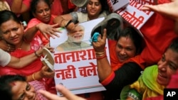 Aktivis oposisi Partai Kongres India memukuli plakat bergambar Perdana Menteri Narendra Modi pada sebuah aksi protes di Mumbai, India. 