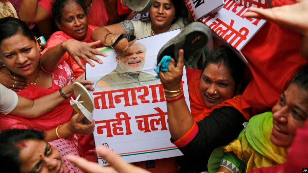 Aktivis oposisi Partai Kongres India memukuli plakat bergambar Perdana Menteri Narendra Modi pada sebuah aksi protes di Mumbai, India. 