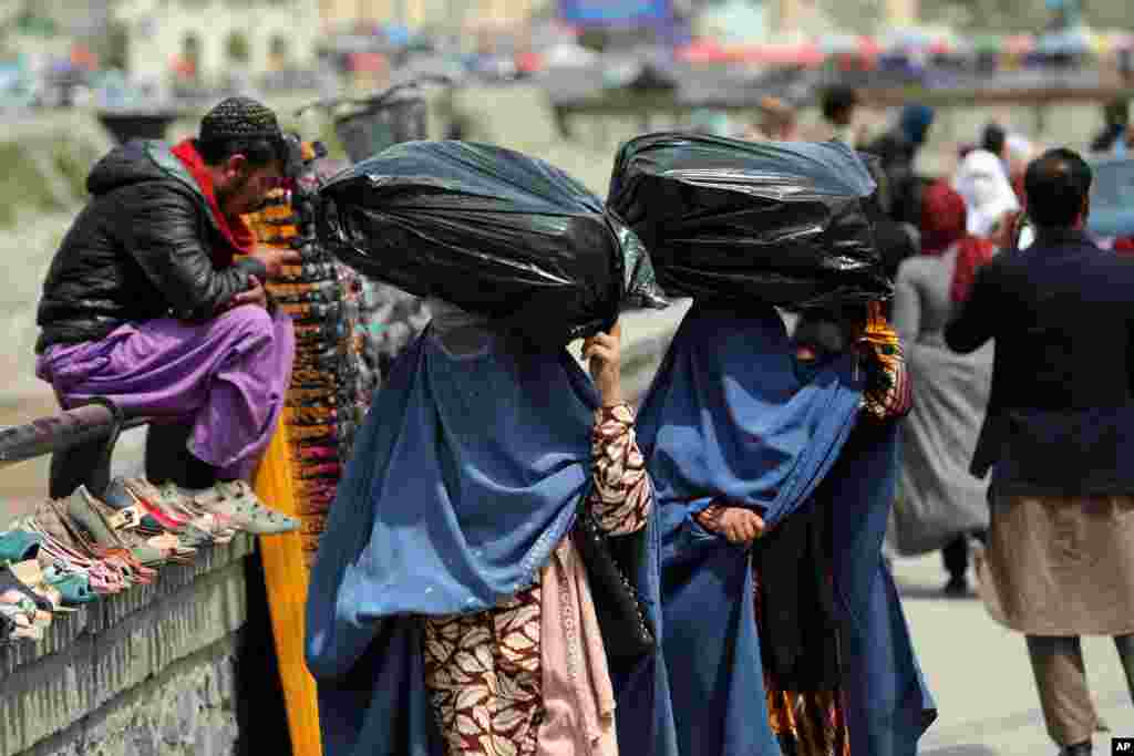 아프가니스탄 카불의 시장에서 여성들이 머리에 인 짐을 나르고 있다.