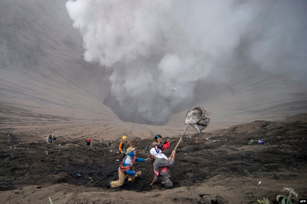 Villagers catch coin offerings released by Hindu devotees of the Tengger tribe during the Yadnya Kasada festival, on the crater of Mount Bromo in Probolinggo, Indonesia, July 21, 2016.