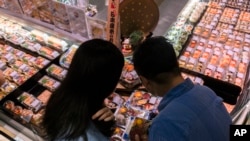 顾客在香港一家超市选购自日本进口的海鲜产品。（美联社2023年7月12日）