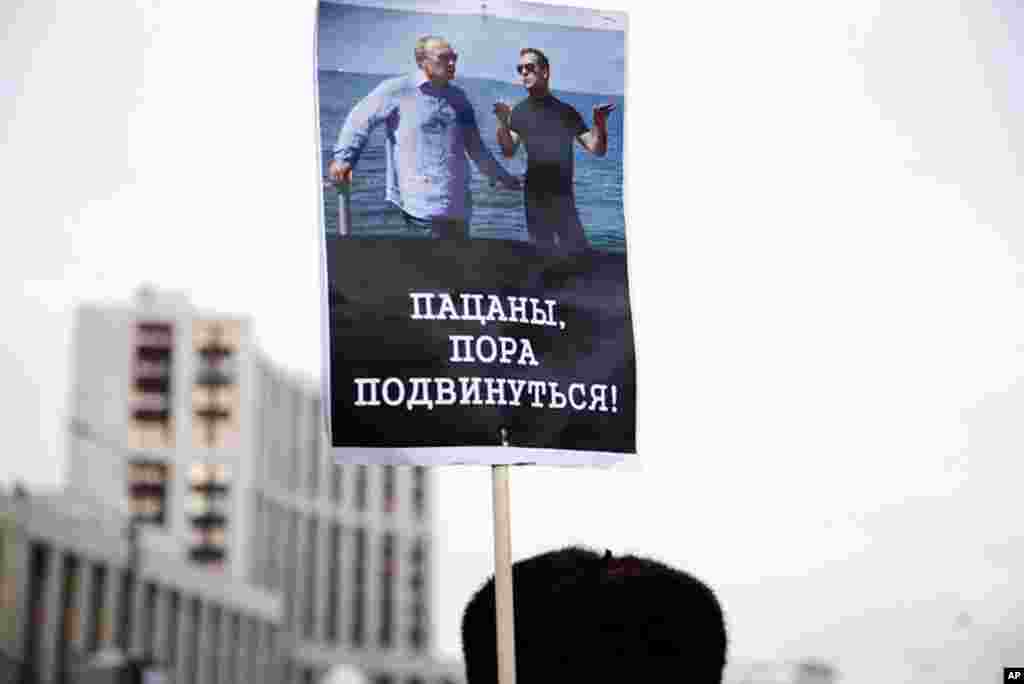 A protester holds a sign that reads. "Guys, it's time to move over!" December 24, 2011. (VOA - Y. Weeks)