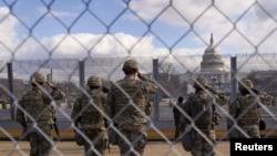 National Guard members salute in front of the U.S. Capitol building during the inauguration of President-elect Joe Biden in Washington, Jan. 20, 2021. 