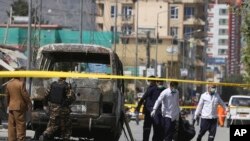 Health workers retrieve a body after an attack that targeted a bus carrying mostly government employees in Kabul, Afghanistan, June 3, 2019.