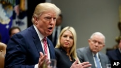 Florida Attorney General Pam Bondi, center, and Attorney General Jeff Sessions, right, watch as President Donald Trump speaks during a meeting with state and local officials to discuss school safety, in the Roosevelt Room of the White House, Feb. 22, 2018.