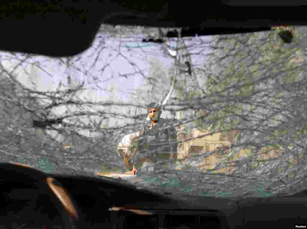 An Afghan man is seen through the cracked window of a vehicle at the site of a suicide car bomb attack in Surkhrod district of Nangarhar province.