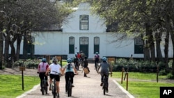 Local tourists are seen during an adventure e-bike tour, run by tour operator Raino Bolz, on the Boschendal Estate near, Cape Town South Africa, Friday, Sept. 4, 2020. 