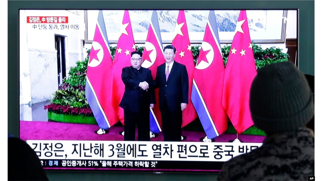 People watch a TV screen showing file footage of North Korean leader Kim Jong Un and Chinese President Xi Jinping, right, during a news program at the Seoul Railway Station in Seoul, South Korea, Jan. 8, 2019. The Korean letters on the screen read: "Kim Jong Un visited China last March."