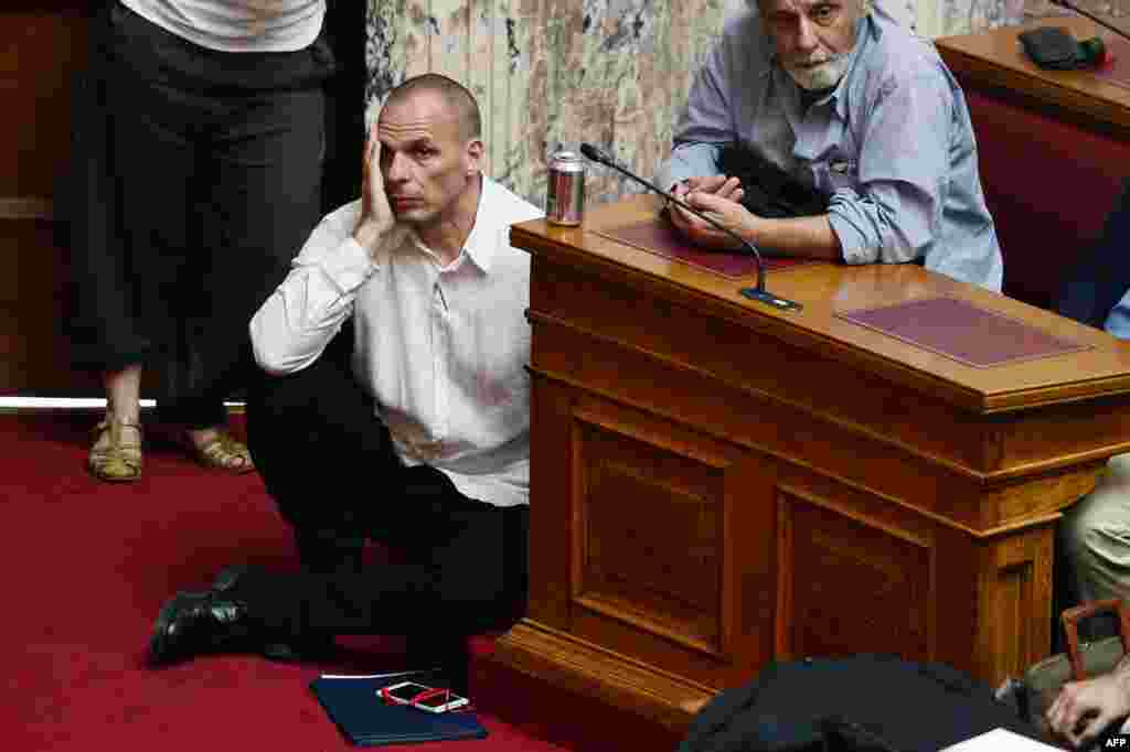 Greek Finance Minister Yianis Varoufakis (L) listens to Prime Minister addressing at the Greek Parliament in Athens.