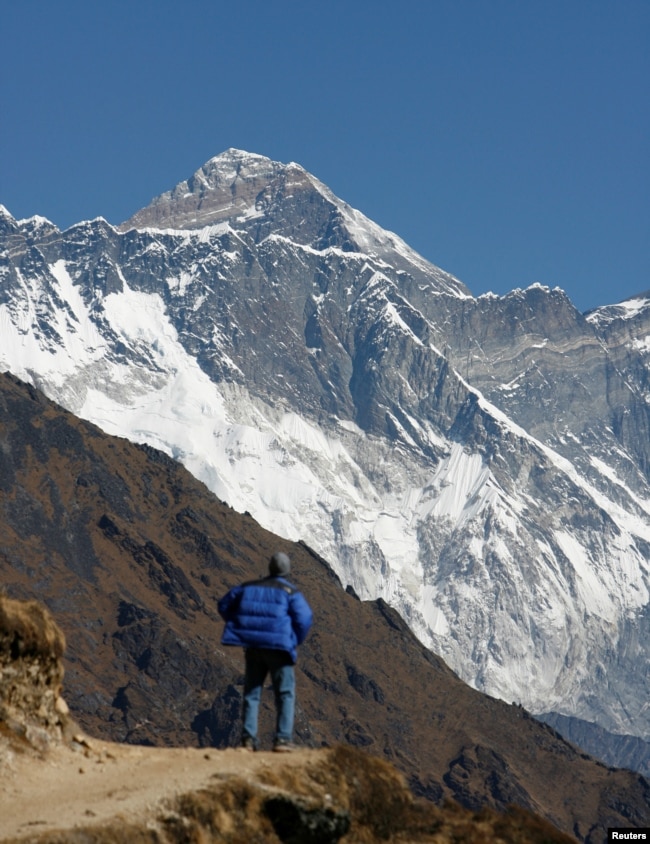 FILE - A tourist looks at a view of Mount Everest from the hills of Syangboche in Nepal on December 3, 2009. (REUTERS/Gopal Chitrakar/File Photo)