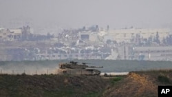 FILE— An Israeli tank moves near the Gaza Strip border, in southern Israel, Wednesday, December 27, 2023. The army is battling Palestinian militants across Gaza in the war ignited by Hamas' October 7 attack into Israel.