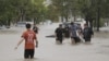 Personas caminan por una calle inundada después de que una poderosa tormenta azotara la ciudad de Bahía Blanca, a 600 kilómetros al sur de la capital de Argentina, el 7 de marzo de 2025.