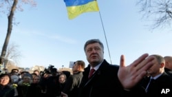 FILE - Ukraine's President Petro Poroshenko speaks with people after a wreath laying ceremony at the monument to the fallen Heroes of the "Heavenly Sotnya (Hundred)," in Kyiv, Ukraine, Nov. 21, 2014.