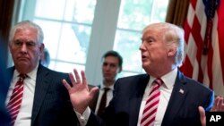  FILE - Secretary of State Rex Tillerson, left, and White House Senior Adviser Jared Kushner listen as President Donald Trump speaks during a Cabinet meeting in the Cabinet Room of the White House in Washington, June 12, 2017.