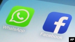 Logo WhatsApp dan Facebook app dalam ponsel.