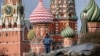 Una persona de seguridad está de guardia en el parque Zaryadye, con la torre Spasskaya del Kremlin y la Catedral de San Basilio vistas al fondo, en el centro de Moscú el 24 de marzo de 2020. 