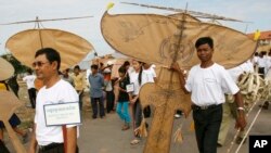 Cambodian people hold their kites before their kite flying at an annual traditional kite flying event in Phnom Penh, Cambodia, Friday, Dec. 5, 2008. Kite flying was one of the royal "ceremonies of the twelve months", according a National Kite Museum. (AP Photo/Heng Sinith)