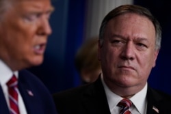 Secretary of State Mike Pompeo, right, listens as President Donald Trump speaks during a coronavirus task force briefing at the White House, March 20, 2020, in Washington.