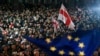 Protesters wave Georgian national and EU flags during a rally against alleged violations in recent parliamentary elections, in Tbilisi, Georgia, Nov. 4, 2024. 