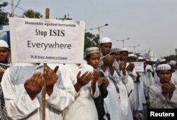 FILE - Activists from a Muslim group pray for the victims of the attacks in Paris, in Kolkata, India.