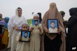 A family from a Pakistani tribal area display pictures of a missing family member during a rally in the northwestern city of Peshawar, Pakistan, Apr. 8, 2018.