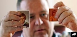 In this Thursday, Feb. 13, 2020, photo, James Kretschmer holds photographs of himself at age 11 and 12 during an interview in Houston. Kretschmer says he was sexually abused by a Scout leader over several months in the mid-1970s in the Spokane, Washingto
