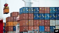 FILE - A container is loaded onto a cargo ship at the Tianjin port in China.